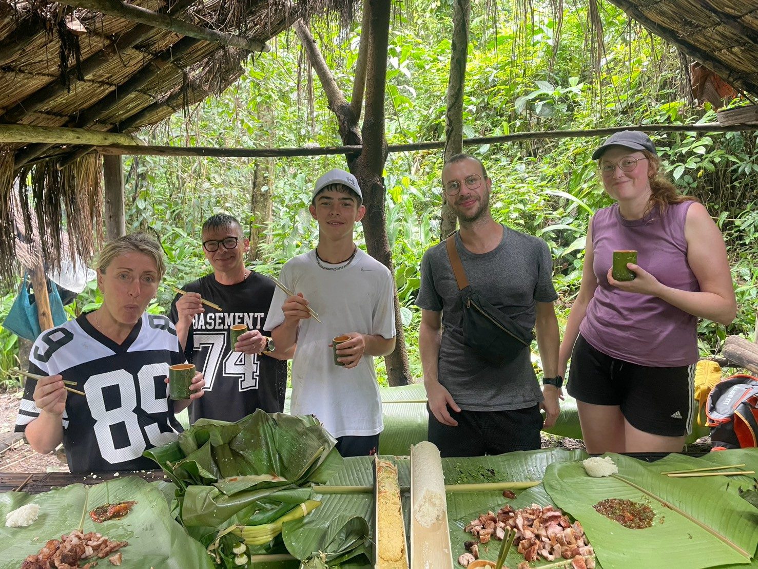 Guests with lunch cooked inside green bamboo